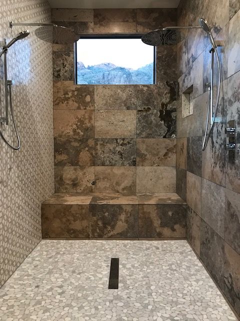 Walk-in shower with natural stone materials and two shower stations with four total functions