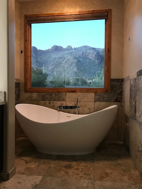 Extra deep soaking tub with matching Travertine Argento wainscoting
