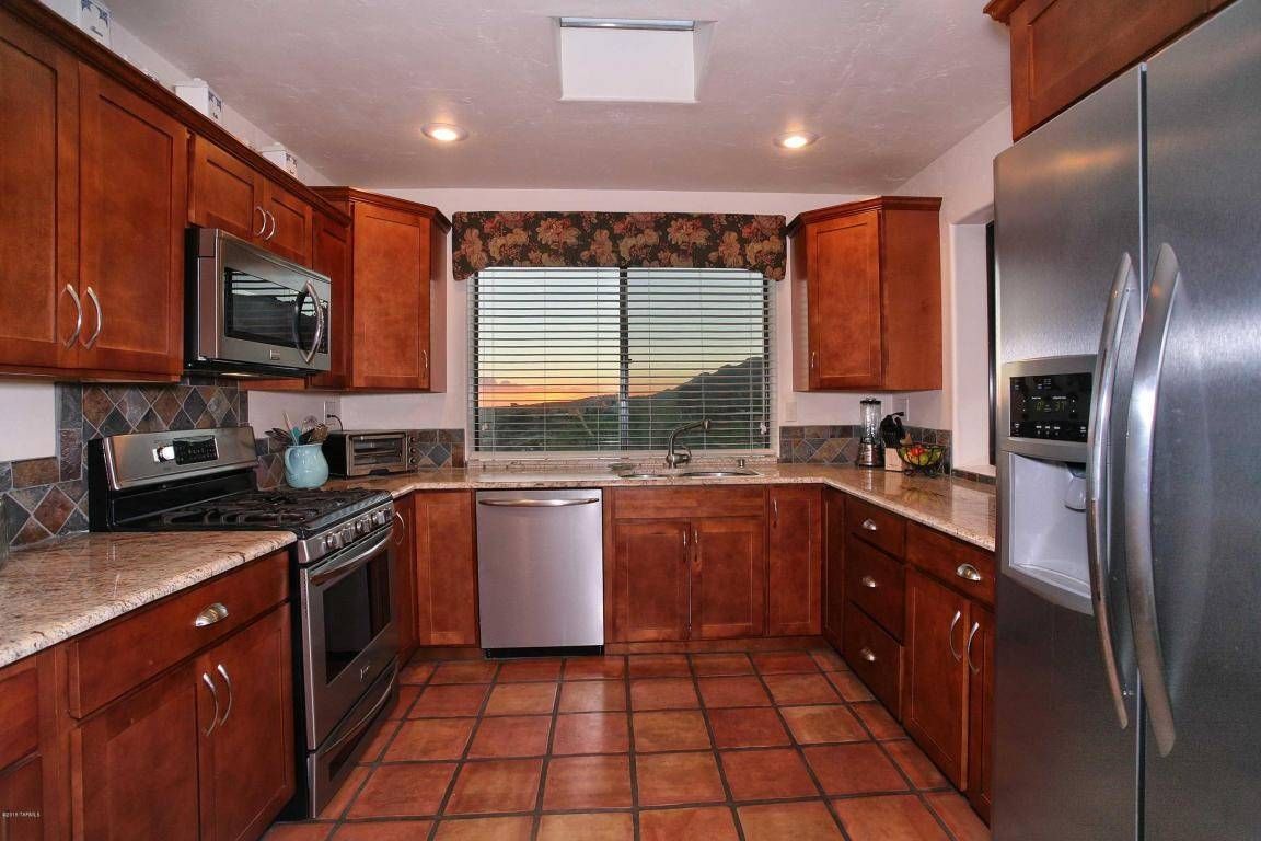 Enlarged kitchen to provide space for an "eat-in" area by adding a small matching masonry addition and matching the home's existing Saltillo tile using a faux patina stain