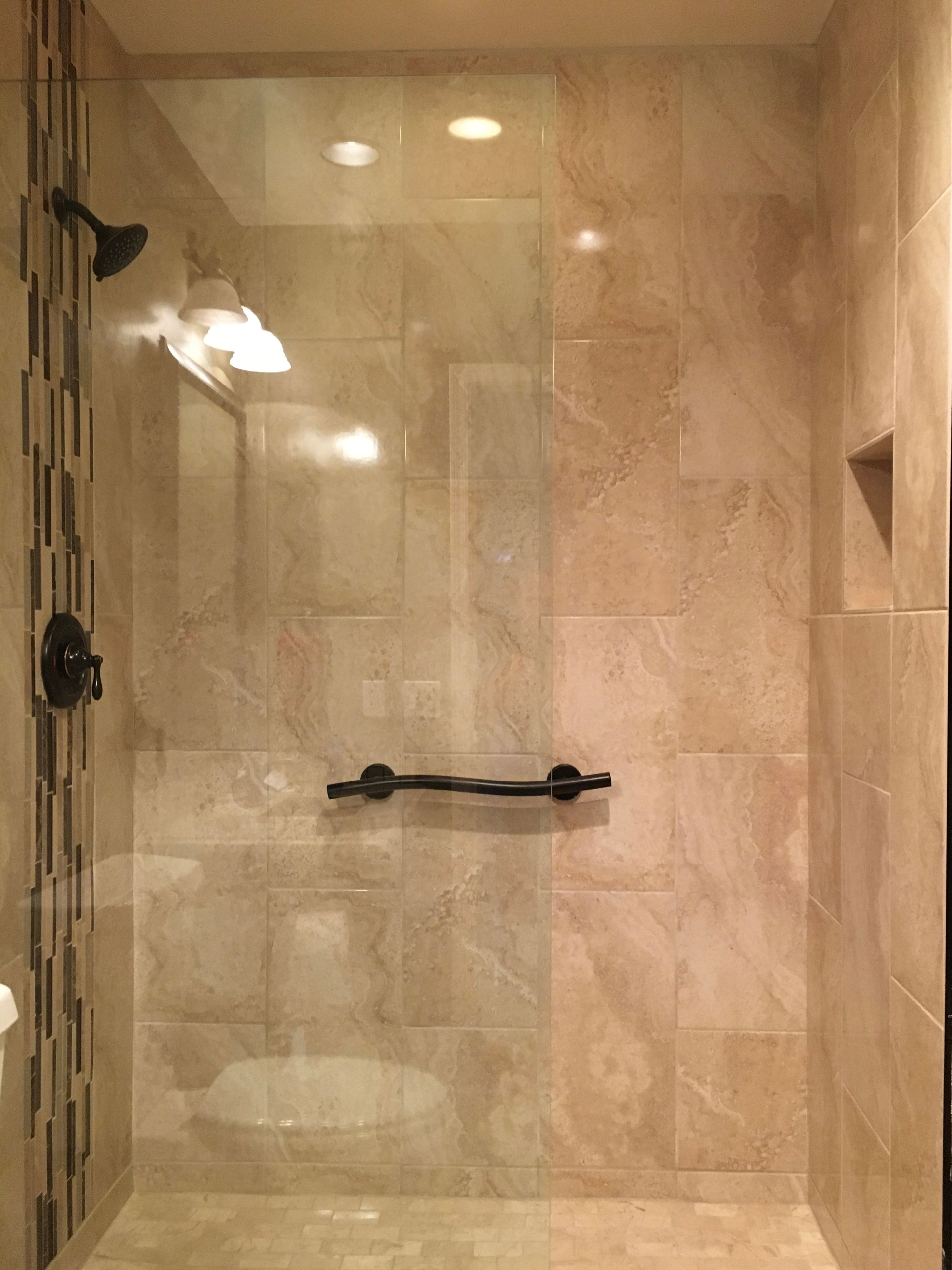 Bathtub to walk-in shower conversion with vertical tile pattern and decorative "waterfall"